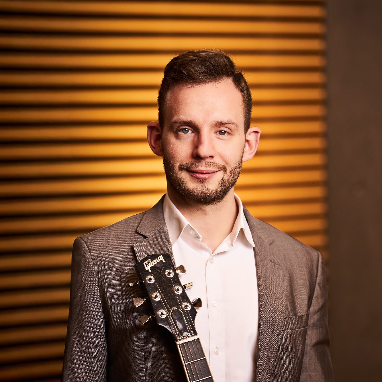 Daniel Hirth als Teil von Clarissi.co ist porträtiert mit einer Gitarre.