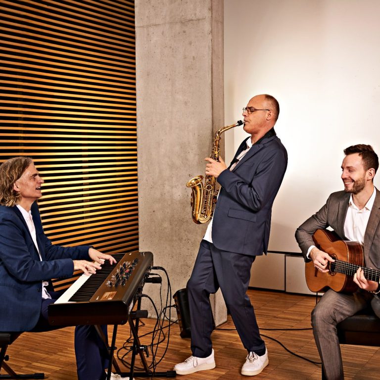 Das Ensemble Clarissi.co mit Saxofon, Gitarre und Piano sorgt für stilvolle Livemusik bei einer Hochzeitsfeier.